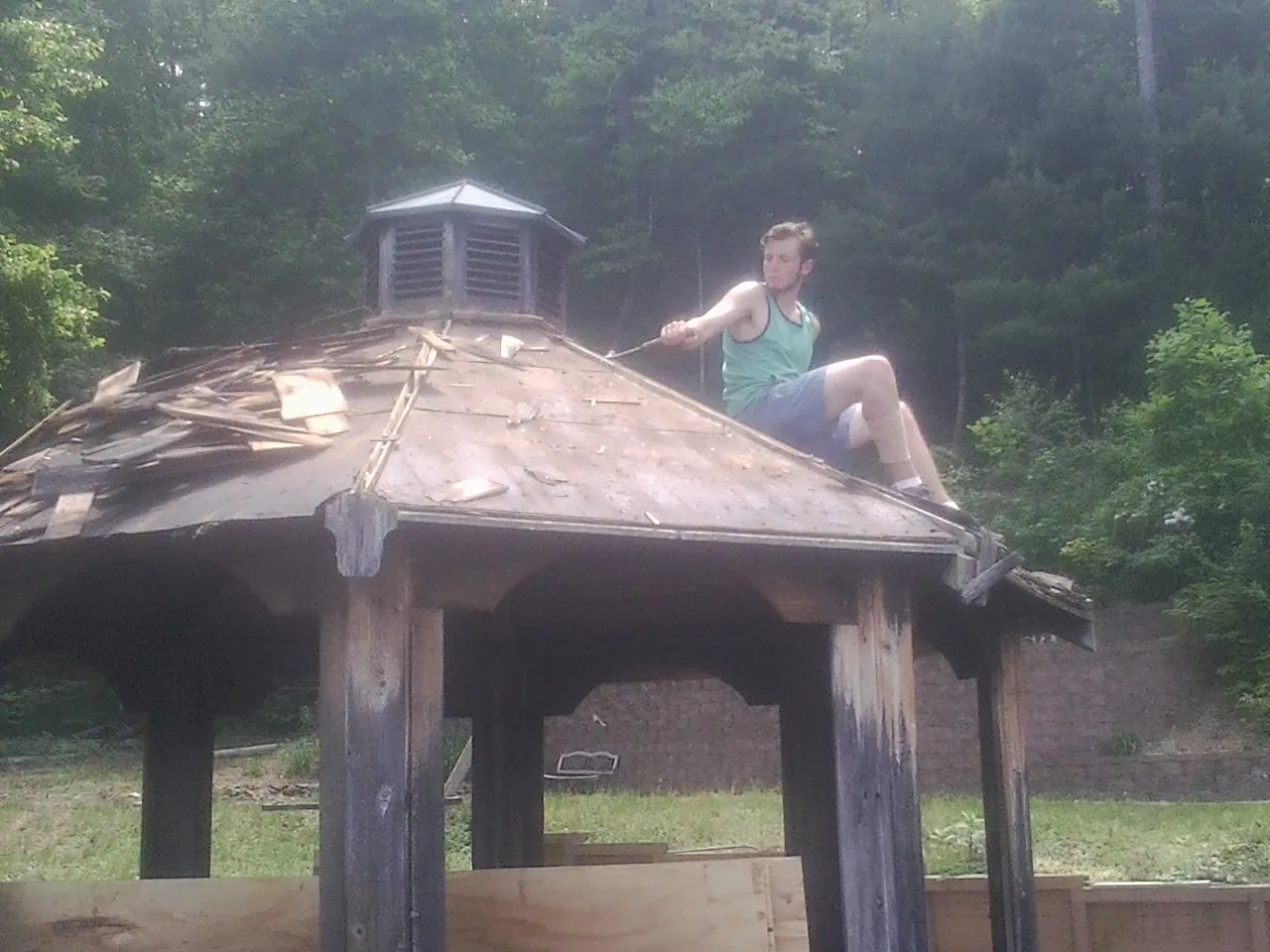 Tearing the old roof off a wooden gazebo before new shakes in Blaine